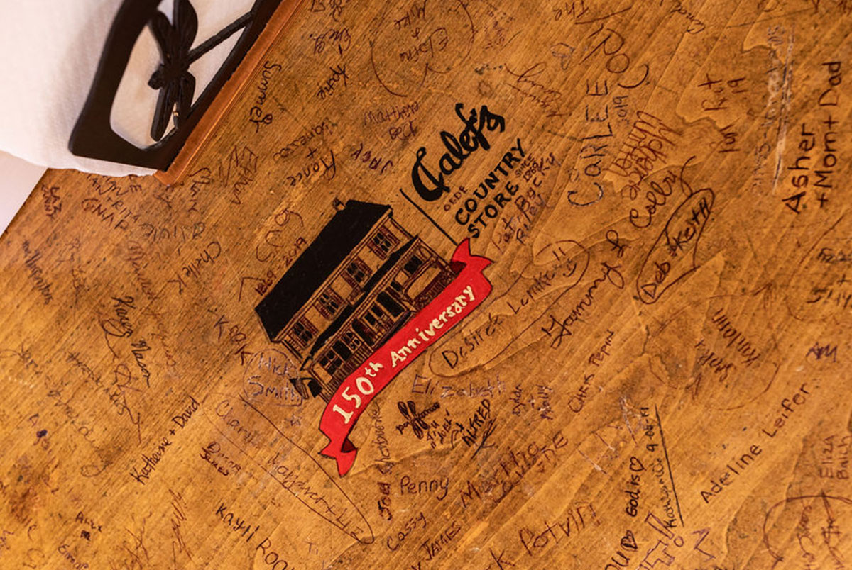 Calef's table with 150year anniversary logo and customer signatures